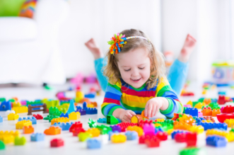 Farebné LEGO kocky vysypané na stole pripravené na skladanie.